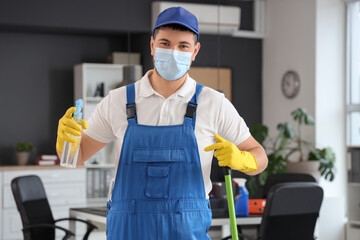 Male worker of cleaning service with mop and detergent in office