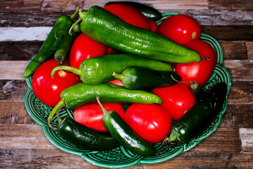 Various peppers, and tomatoes on a plate. 