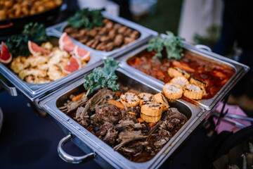 Valmiera, Latvia - August 10, 2023 - Buffet trays filled with various foods including meat, grilled...