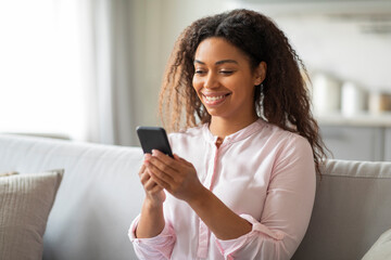 Woman using smartphone with relaxed pose at home