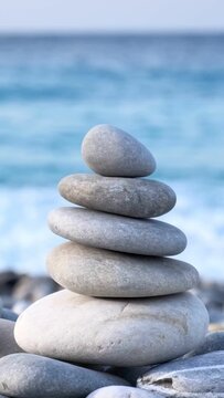 Zen meditation background - balanced stones stack cairn close up on sea beach