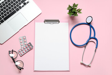 Blank clipboard with stethoscope, pills and laptop on pink background. World Health Day