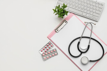 Blank clipboard with stethoscope, pills and computer keyboard on white background. World Health Day