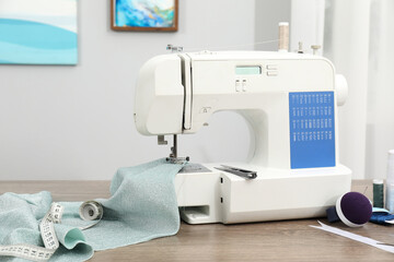 White sewing machine and cloth on wooden table indoors