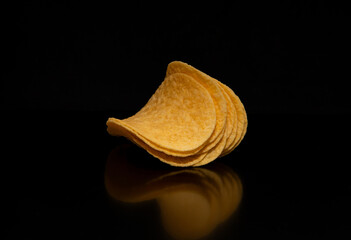 Close-up with potato chips on a black background