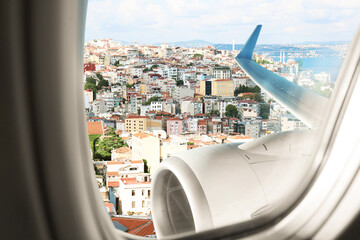 Beautiful city with buildings, view through airplane window during flight