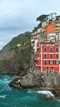 Houses on cliff in Riomaggiore village popular tourist destination in Cinque Terre National Park a UNESCO World Heritage Site, Liguria, Italy. With camera panning
