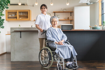 車椅子に座るシニア女性と介護士・理学療法士・介護スタッフの女性

