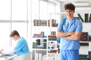Male medical intern with backpack in library