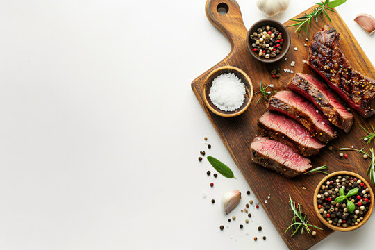 medium rare steak on the old wooden cutting board, ready to cook, marble background, top view, copy space