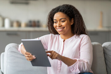 Lady holding tablet with engaging smile at home