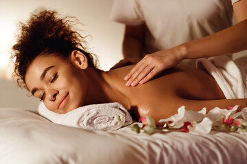 Obraz na płótnie Canvas Enjoying a luxurious shoulder massage in a spa environment
