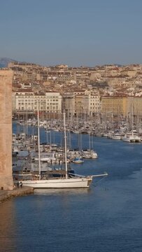 Yachts coming to Marseille Old Port (Vieux-Port de Marseille) on sunset and Fort Saint-Jean. Marseille, France. Camera pan