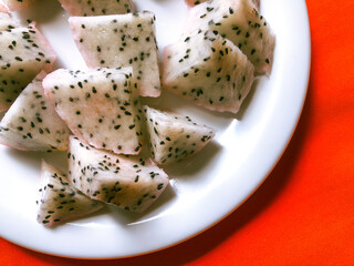 White pitaya cut into pieces on white porcelain plate with copy space