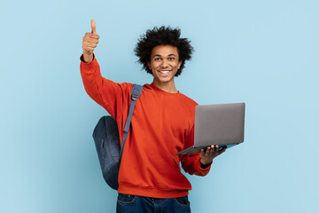 Cheerful guy with laptop giving thumbs up