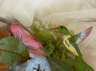 Amber tint fabric acts like a screen when you gaze at colorful painted metal hummingbird sculpture...