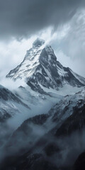 Lonely snow-capped mountain under swirling clouds - The image represents the majesty of a solitary mountain peak enveloped by swirling, ethereal clouds, suggesting isolation