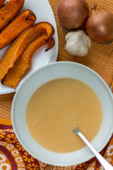 Cream of pumpkin soup with roasted pumpkin slices top view.