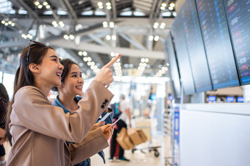 Asian young women passenger checking depature boarding pass in airport. 