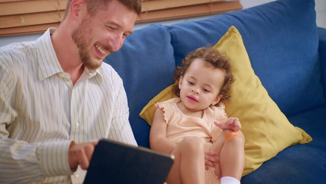 Caucasian father spend leisure time with baby gir in living room at home. 