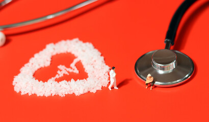 Obese people are more vulnerable to cardiovascular disease. Stethoscope on red background, salt in...