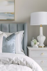 A closeup shot of the bedside table in an elegant bedroom, featuring soft white and blue accents with golden lamp details