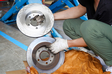 Car brake repairing in garage,Brand new brake discs for garage cars. Auto mechanic,in process of new tire replacement,