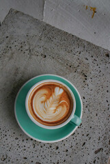 Cup of coffee with smoke and coffee beans on old wooden background