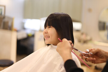 美容室で髪の毛を切る女の子　ヘアドネーションイメージ