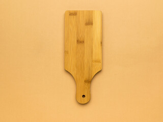 Classic wooden cutting board on beige background.