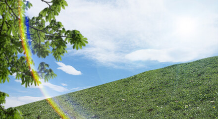 春・夏　煽りで見上げた丘・土手の野原の坂道　さわやかな晴天の青空と雲の背景壁紙 太陽の日差しと光レンズフレア　アウトドア・夏休み・祝日・行楽・観光・旅行・ゴールデンウィーク・ウォーキング・散歩のイメージ素材 - obrazy, fototapety, plakaty
