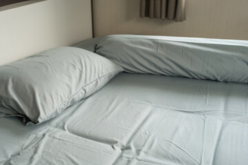 Closeup of pillows and bolster on a simple blue bed