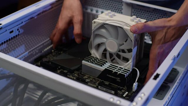 Gamer male installing new graphics card of latest model on motherboard. Stages of upgrading or assembling PC. Closeup of computer technician assembling desktop computer with new parts, slow motion.