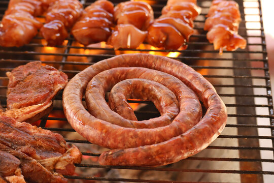 South African braai meat including Boerewors and chicken kebabs. sausages on grill
