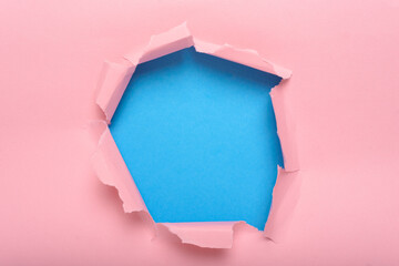 Center torn pink paper background revealing a blue background