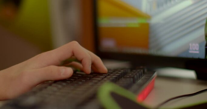 Close-up fingers on keyboard of boy playing education game. he navigates through the virtual challenges presented on the screen, each keystroke a deliberate action in the pursuit of knowledge. 