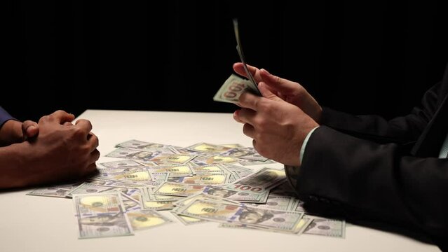 Businessman counting money. Dividing money. Greed grabs dollar bills. Corruption. Financial partnership. The concept of corruption in business finance.
