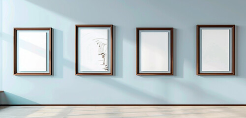 An avant-garde art gallery featuring four elegant chocolate brown frames on a light blue wall,...