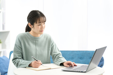 リビングで勉強をする女性