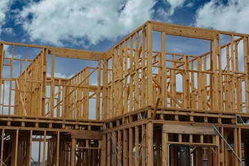 New suburban house construction with timber framing and a blue sky