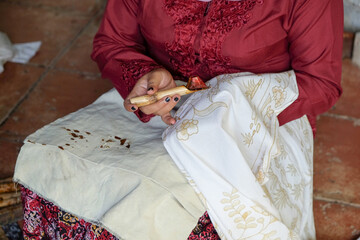 The process of making traditional written batik using canting.