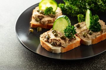 Open sandwiches with pate, fresh cucumber, capers, and parsley.