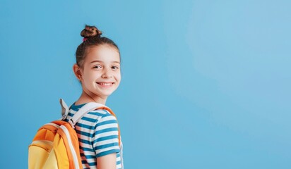 Smiling Young Girl With Backpack Ready for School on a Bright Blue Background - 793596732