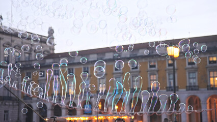 Happy people enjoy soap bubbles performance. Fun street artist create lot foam circles. Colorful...