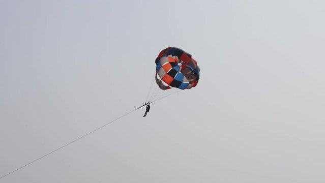 parasailing adventure activity with bright blue sky background at day from flat angle