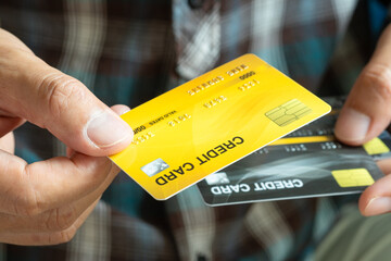 Man holding several credit cards and he is choosing a credit card to pay and spend Payment for...