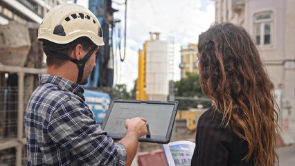 Engineer constructor discuss build plan with investor woman. Builder guy show construction site project tablet pad. Worker tell blueprint client. Man work city street Customer look at new house scheme