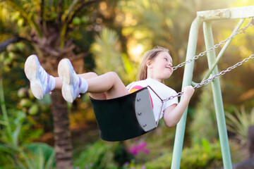 Child swinging on playground. Kids swing. - 793604356