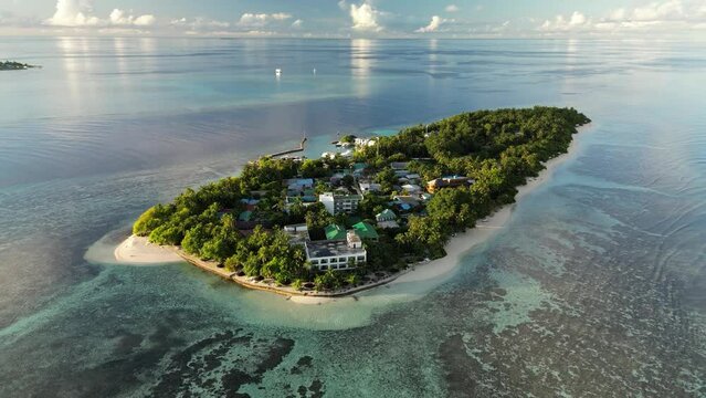 Aerial drone shot, panning around the small local island of Thinadhoo during sunrise in the Vaavu Atoll, Maldives