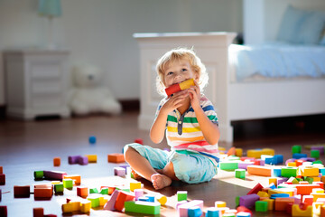 Child playing with colorful toy blocks. Kids play. - 793605703